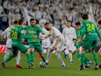 Benzema controla el balón entre varios jugadores de la Real Sociedad.