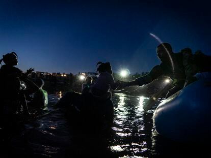 Un agente fronterizo de Estados Unidos ayuda a una niña a subirse a una lancha en el Río Bravo la noche de este jueves.