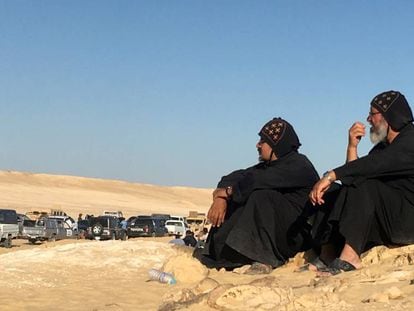 Dos hombres sentados tras el atentado de este viernes contra un grupo de coptos que viajaban a un monasterio al sur de Egipto. 