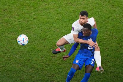 El iraní Morteza Pouraliganji pugna por el balón con el estadounidense Tim Weah.