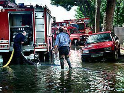 Los bomberos achicaban ayer agua en uno de los márgenes de la autopista.