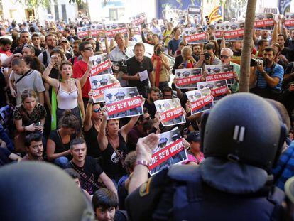 Manifestants davant del cordó policial a la seu de la CUP.