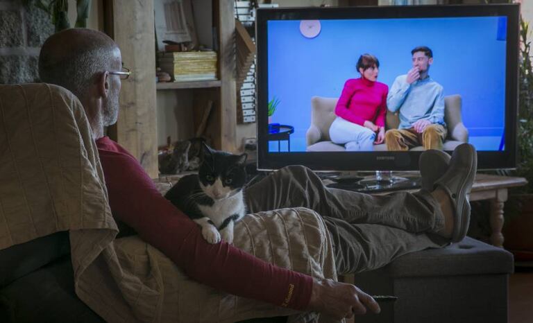 Un hombre ve la televisión en su casa.