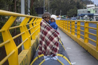 Una madre con su hijo en el puente fronterizo.