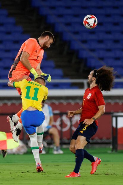 El portero español Unai Simón despeja el balón ante el extremo brasileño Antony, en la final de fútbol masculino entre Brasil y España.