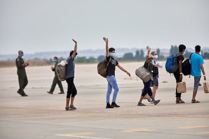 Un grupo de jóvenes afganos saludan, antes de subir a un avión estadounidense para ser trasladados a Alemania, en la base aérea de Torrejón de Ardoz, el 24 de agosto de 2021, en Madrid.