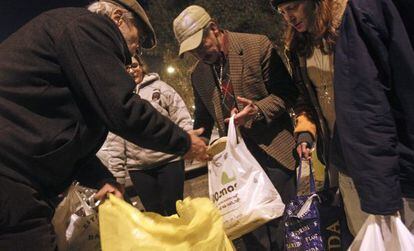 Un voluntario de la ONG Re-Food reparte entre gente sin recursos de un barrio de Lisboa comida donada por los restaurantes.