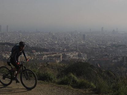 Una ciclista por la carretera de les Aigües (Barcelona) durante un episodio de contaminación