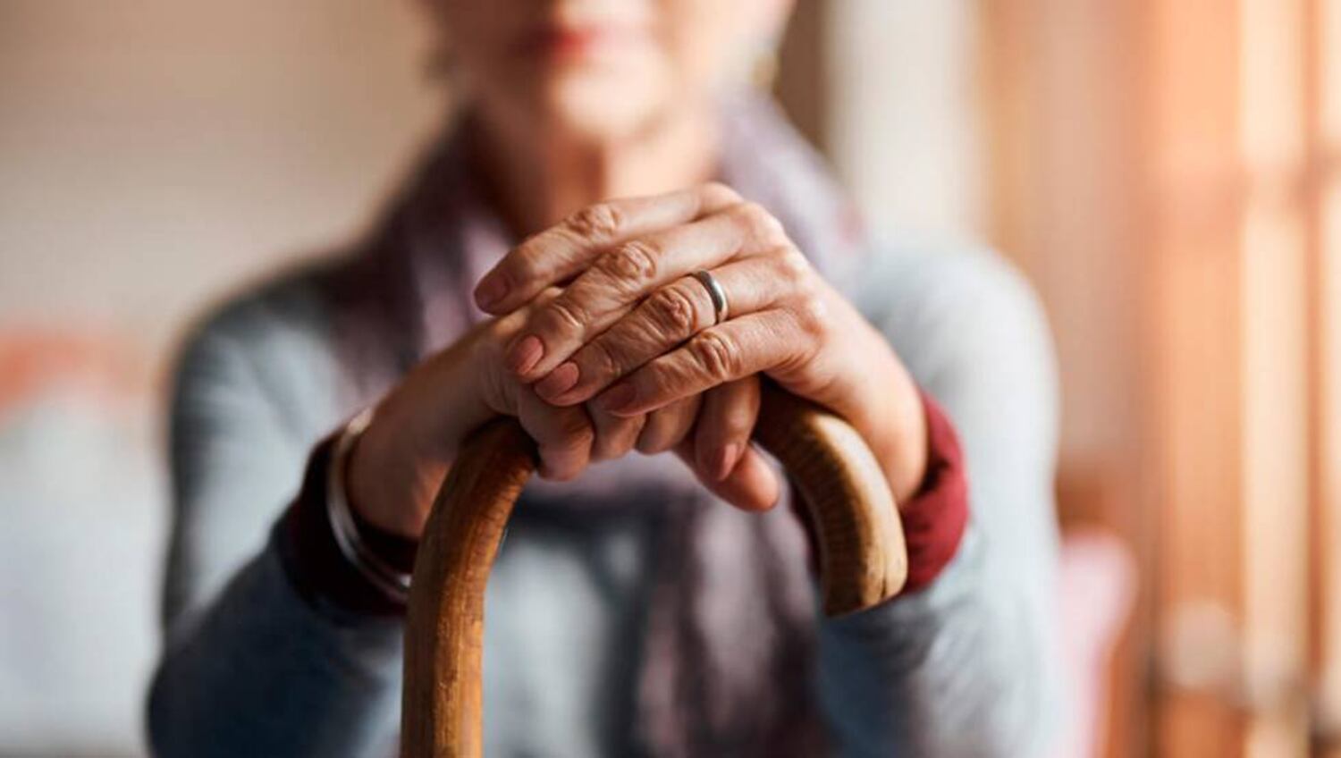 Un anciana se apoya sobre su bastón.