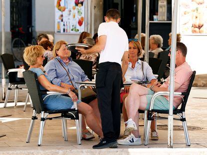 Varios turistas son atendidos por un camarero en Valencia.