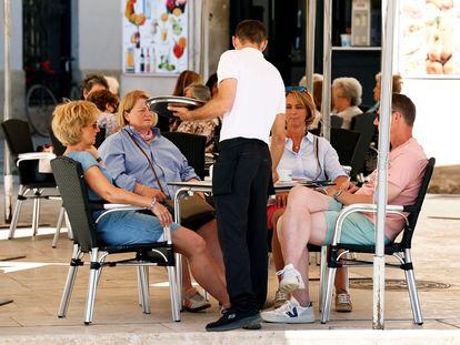 Un camarero atiende a varios clientes en una terraza en Valencia en 2021.