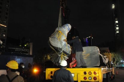 Los operarios retiran la estatua de Colón de la avenida Reforma en Ciudad de México.