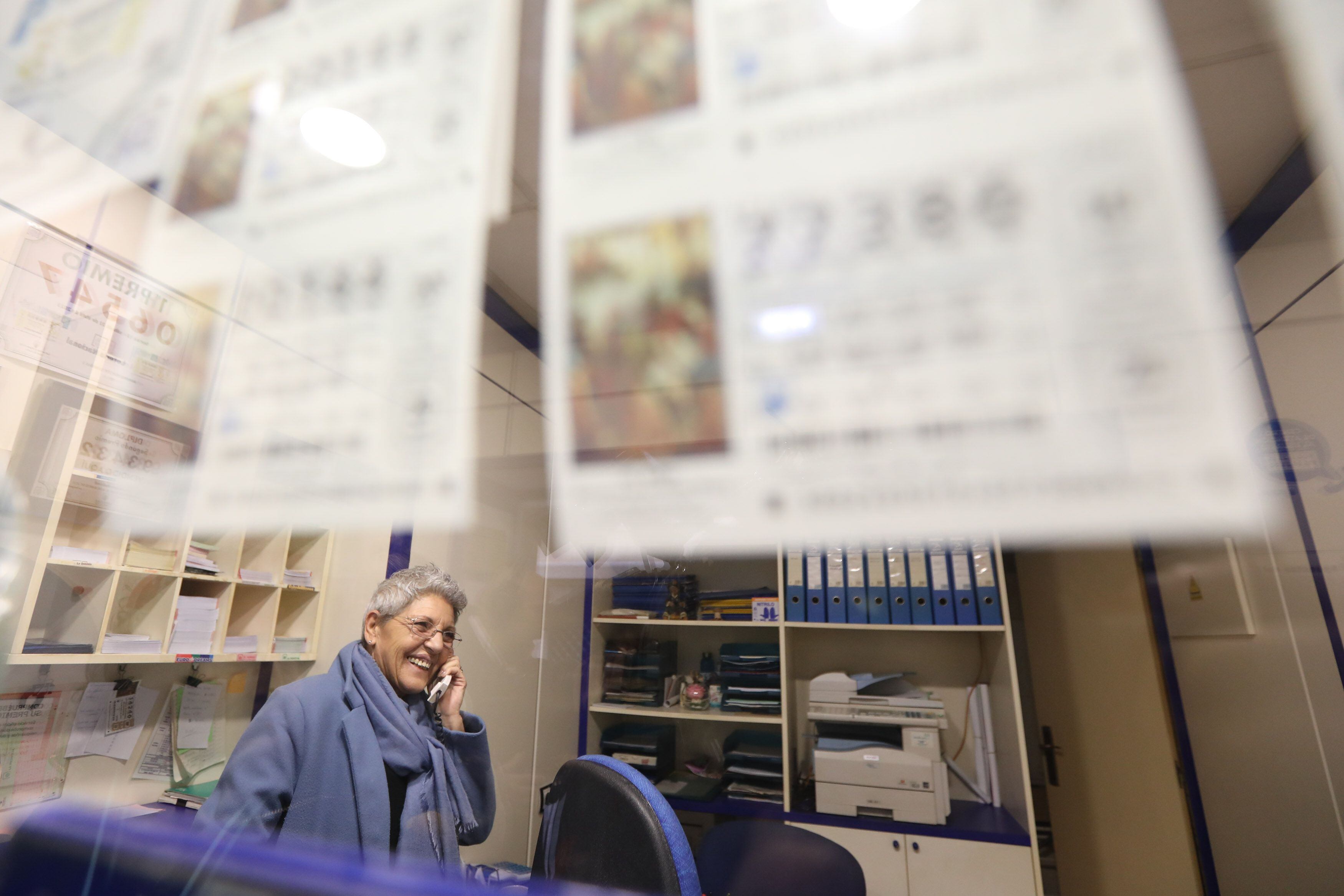 La lotera, de la administración de la calle Padre Tomás Lorenzo de Teruel, llama por teléfono tras haber vendido uno de los quintos premios del Sorteo Extraordinario de Lotería de Navidad 2023, correspondiente al número 54274.