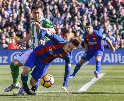 El centrocampista del Barcelona, Denis Suárez (centro), cae ante el defensa rumano del Betis, Alin Tosca.