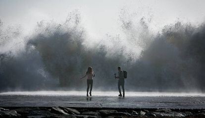 Una parella intenta fer una foto a la platja de Barcelona.