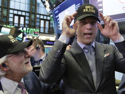 Operadores de la Bolsa de Nueva York con gorras que señalan: "Dow 23.500"