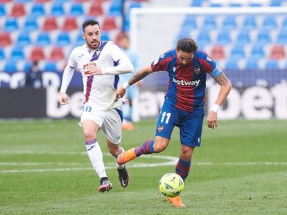 Morales conduce el balón ante Expósito en el partido contra el Eibar este domingo en el Ciutat de Valencia.