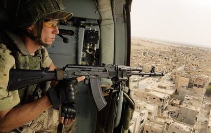 Un soldado ruso vigila desde un helic&oacute;ptero la ciudad siria de Palmira. 