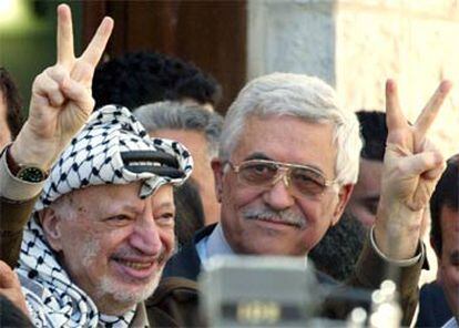 Yasir Arafat hace el signo de la victoria junto a Abu Mazen, a la salida de la votación parlamentaria de ayer.