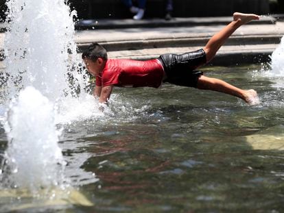 Un niño se refresca en una fuente en la Alameda Central la Ciudad de México.