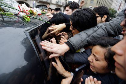 Fans de Gustavo Cerati junto al coche fúnebre que traslada los restos mortales del cantante al cementerio en Buenos Aires (Argentina).