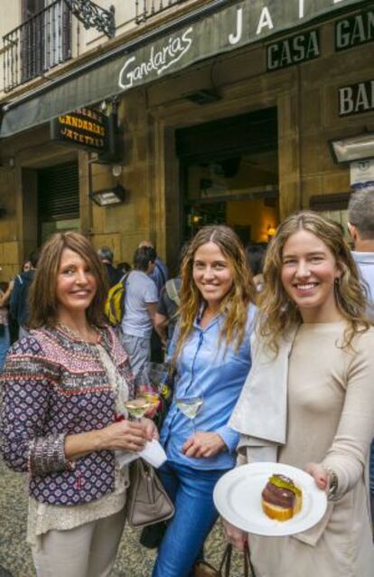 Tres mujeres muestran un pincho en la puerta de Gandarias.