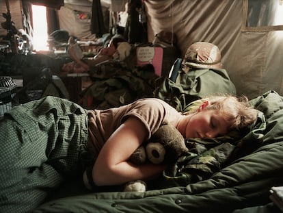 La enfermera Amy Stuart abraza un oso de peluche mientras duerme en una unidad quirúrgica móvil durante la Guerra del Golfo, Arabia Saudí, 1991.