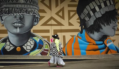 Una madre pasea con su hijo junto a unos grafitis en las calles de Johanesburgo (Sudáfrica).