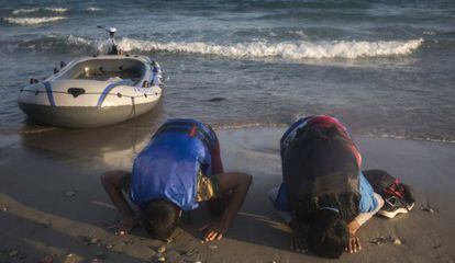 Dos inmigrantes procedentes de Pakistán rezan a su llegada a la costa de la isla griega de Kos.