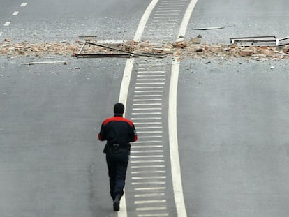 Un 'ertzaintza', junto a los restos de la explosión de una bomba de ETA que no causó víctimas cerca de una empresa siderúrgica, en Bilbao en 2006.