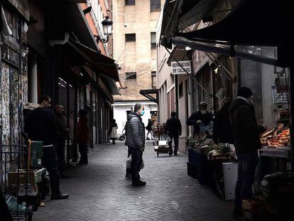 Un hombre espera su turno en una frutería del Mercado de Antón Martín en Madrid. 