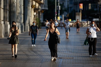 En el centro de la imagen, una mujer sin máscara en el centro de Barcelona.