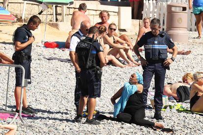 Una mujer se quita la camisa mientras la policía le pone una multa en Niza.