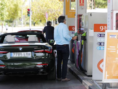 Unas personas repostan combustible en una gasolinera de Madrid.