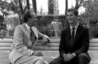El rey Juan Carlos ríe junto a su hijo, el príncipe Felipe, sentados en un banco de Zarzuela.