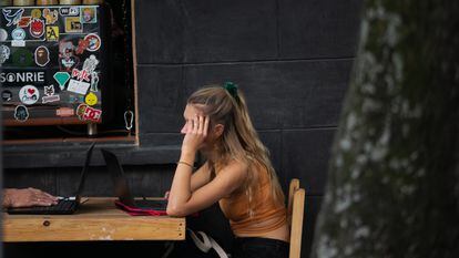 Una joven extranjera utiliza su computadora portatil en un café en la calle de de Orizaba, en Ciudad de México, el 11 de noviembre de 2022.