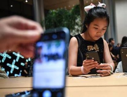Una joven observa un iPhone.