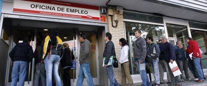 Desempleados esperando a las puertas de una oficina de empleo.