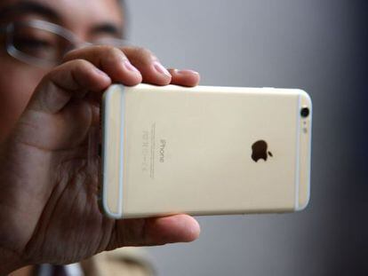 Un hombre sujeta un iPhone 6, un teléfono de Apple.