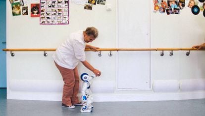 El robot ayuda a caminar a una paciente en rehabilitación.