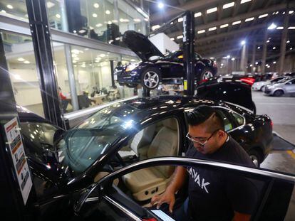 Un trabajador de la ‘startup’ de compra y venta de autos mexicana Kavak inspecciona una unidad, en 2020.