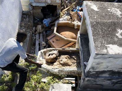 Un trabajador mueve un ataúd con los restos de un cadáver exhumado, en una vieja tumba en el cementerio nacional de Puerto Príncipe, en Haití.