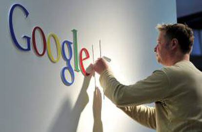 Un hombre da los últimos retoques al logo de Google. EFE/Archivo