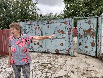 Zoya Mekotina, a resident of Vilkhivka, Ukraine, in front of the door of her house, shot by Russian soldiers.