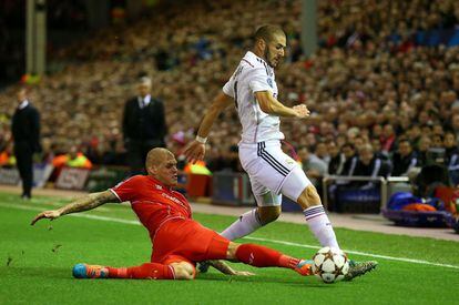 El jugador el Liverpool Martin Skrtel pelea desde el suelo un balón con Karim Benzema.