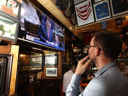 Un hombre en una taberna de Dublín viendo en la televisión al ministro de Finanzas, Michael McGrath.