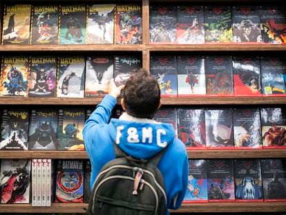 Un adolescente elige un cómic en una tienda.