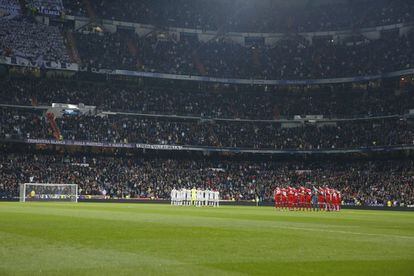 Los jugadores del Real Madrid (i) y del Sevilla (d), durante el minuto de silencio en memoria de Gregorio Paunero Martín, exdirectivo del Real Madrid fallecido a la edad de 100 años, antes del inicio del partido.