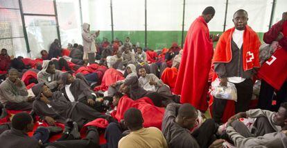 Los inmigrantes esperan pasar a disposici&oacute;n de las autoridades tras ser atendidos en un polideportivo de Tarifa.