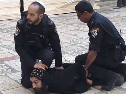 Agentes israelíes detienen a un monje copto que se manifestaba junto al Santo Sepulcro de Jerusalén, este miércoles.